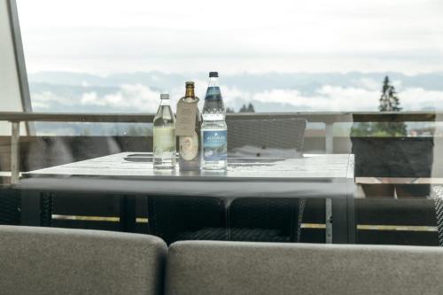 a table with bottles sitting on top of a balcony at HEIMATEL - Suiten, Apartments und Studios in Scheidegg