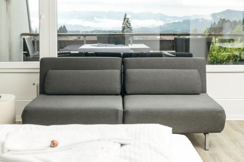 a living room with a couch and a table at HEIMATEL - Suiten, Apartments und Studios in Scheidegg
