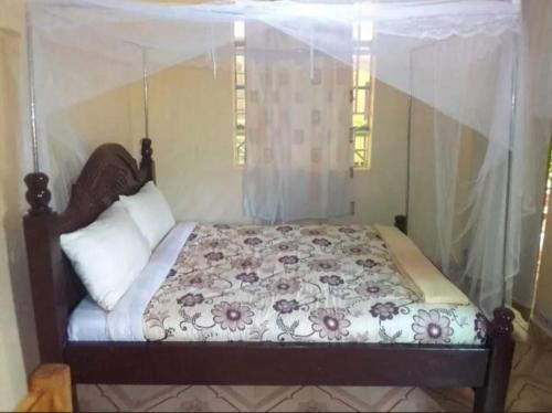 a bedroom with a bed with a canopy at Mong'are Lodge and Restaurant, Narok in Narok