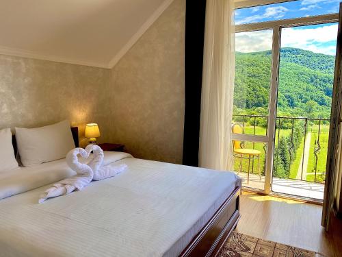 ein Schlafzimmer mit einem Bett mit Schwänen aus Handtüchern in der Unterkunft садиба В ГОРАХ у Аліни in Solotschyn