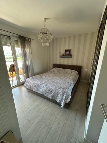 een slaapkamer met een bed en een kroonluchter bij Apartment Timka in Mostar
