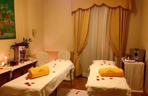 a hospital room with two beds with flowers on them at Hotel Holiday Sul Lago in Bolsena
