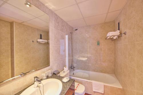 a bathroom with a sink and a tub and a toilet at Ilusion Markus & Spa in Can Picafort