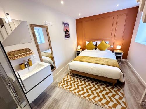 une chambre avec un lit, un lavabo et un miroir dans l'établissement La Terre du Mont, à Avranches