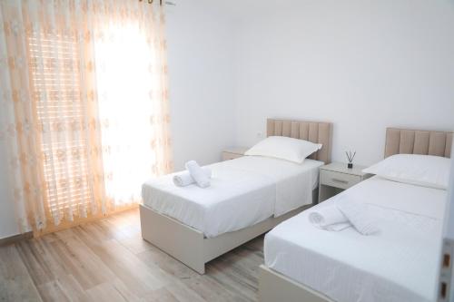 a bedroom with two beds and a window at Amla's Villa in Berat