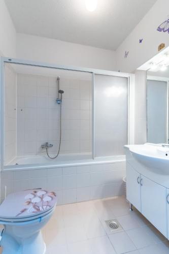 a bathroom with a shower and a toilet and a sink at Apartman Laura in Cres