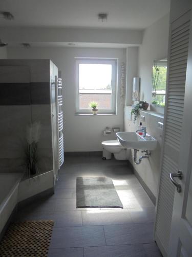 a bathroom with a sink and a toilet and a tub at Ferienwohnung Papst in Sittensen