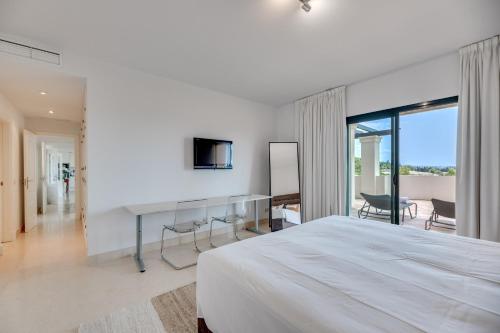 a bedroom with a large white bed and a television at Spacious 2-bed apt Capanes del Golf in Benahavís