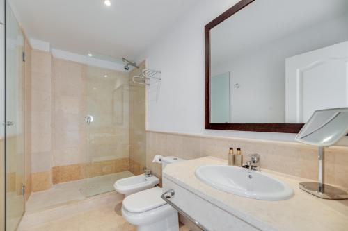 a bathroom with a sink and a toilet and a mirror at Spacious 2-bed apt Capanes del Golf in Benahavís