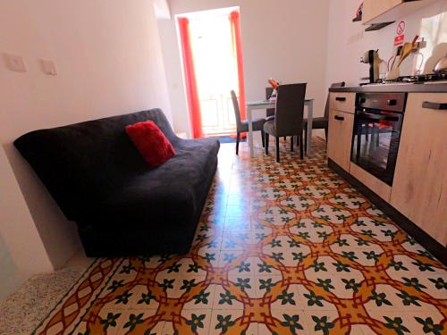 a living room with a couch and a kitchen at Charming Townhouse - Steps from Waterfront in Marsaxlokk