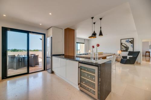 an open kitchen with a counter and a living room at Spacious 2-bed apt Capanes del Golf in Benahavís