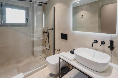 a white bathroom with a sink and a shower at ELA FIVE RESIDENCES in Athens