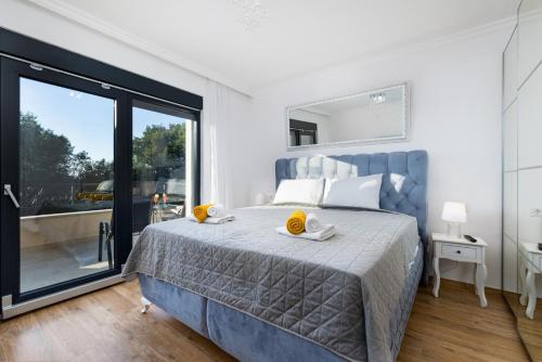a bedroom with a large bed and a large window at Villa Laura in Malinska