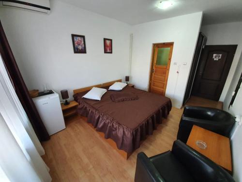 a small bedroom with a bed and a chair at Eforie Brio in Eforie Nord