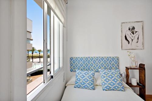 ein Schlafzimmer mit einem Bett und einem großen Fenster in der Unterkunft Precioso Piso Frente Al Mar in Vilanova i la Geltrú