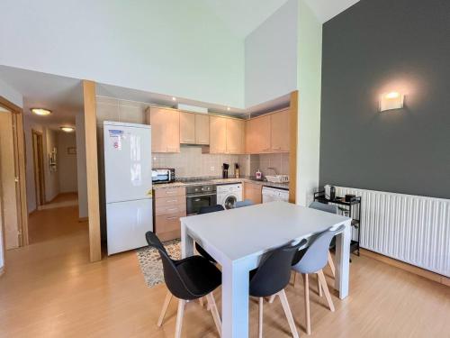 a kitchen with a white table and some chairs at Ático De 3 Habitaciones Con Vistas Soldeu - Parking incluido l by BonesVacances in Soldeu