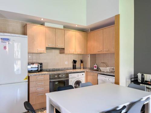 a kitchen with wooden cabinets and a white appliance at Ático De 3 Habitaciones Con Vistas Soldeu - Parking incluido l by BonesVacances in Soldeu