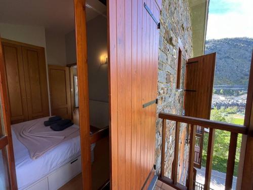 a small bedroom with a bed and a balcony at Ático De 3 Habitaciones Con Vistas Soldeu - Parking incluido l by BonesVacances in Soldeu