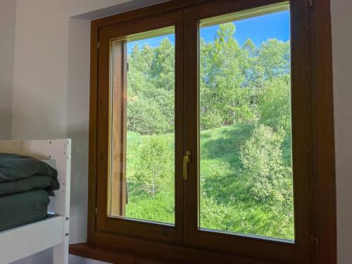 a window in a bedroom with a view of trees at Ático De 3 Habitaciones Con Vistas Soldeu - Parking incluido l by BonesVacances in Soldeu