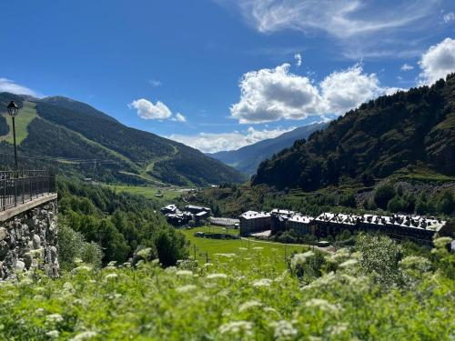 a train traveling through a valley with mountains at Ático De 3 Habitaciones Con Vistas Soldeu - Parking incluido l by BonesVacances in Soldeu