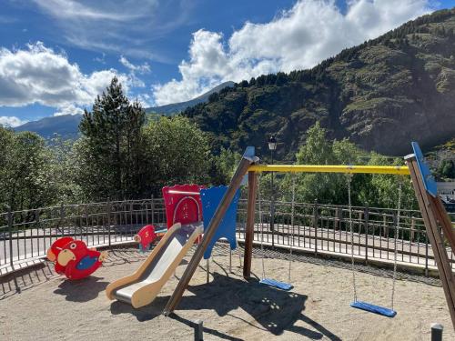 a playground with two slides and a swing at Ático De 3 Habitaciones Con Vistas Soldeu - Parking incluido l by BonesVacances in Soldeu