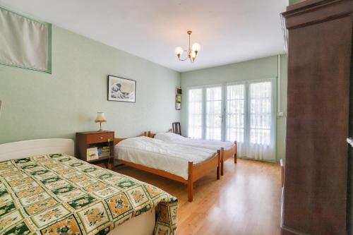 une chambre avec deux lits et une fenêtre dans l'établissement Maison avec jardin à 1km de la plage du Mauret, à Andernos-les-Bains