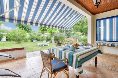 une salle à manger avec une table et des chaises ainsi qu'une terrasse dans l'établissement Maison avec jardin à 1km de la plage du Mauret, à Andernos-les-Bains