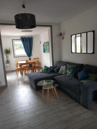 un salon avec un canapé bleu et une table dans l'établissement Maison à louer week-end des 24h, au Mans