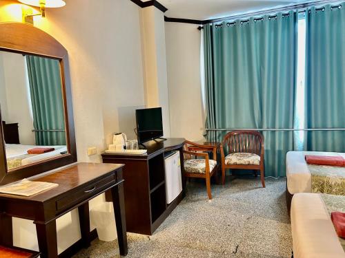 a hotel room with a bed and a mirror at Green House Hotel in Krabi town
