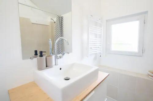 une salle de bain blanche avec un lavabo et une fenêtre dans l'établissement Le Traditionnel - Maison avec Jardin & Parking - Idéal Disneyland & PARIS, à Lagny-sur-Marne