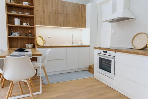 a kitchen with white cabinets and a table and chairs at Artistry Apartment in Komotini