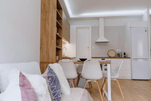 a living room with a table and white chairs at Artistry Apartment in Komotini