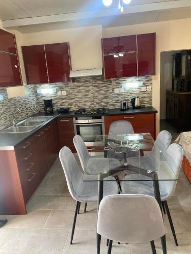 a kitchen with a glass table and white chairs at Sappir House in Pigadhákia