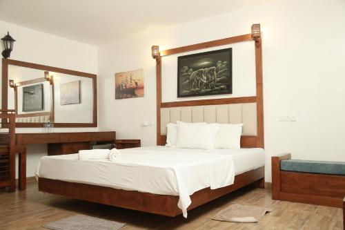 a bedroom with a bed and a desk and a mirror at New Ocean Hill Hotel in Hikkaduwa