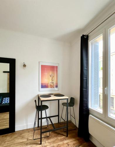 une pièce avec une table et deux chaises et une fenêtre dans l'établissement Studio coeur de ville - proximité plages et Palais des Festivals, à Cannes