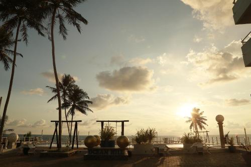 a view of the ocean from a resort with palm trees at New Ocean Hill Hotel in Hikkaduwa