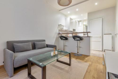 un salon avec un canapé et une table en verre dans l'établissement Marché Ordener - Appartement refait à neuf proche Montmartre, à Paris