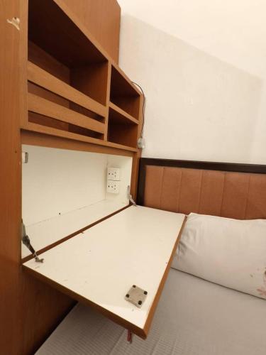 a small room with a bed with a desk at Red Inn Court in George Town