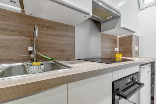 une cuisine avec un évier et un plan de travail dans l'établissement Marché Ordener - Appartement refait à neuf proche Montmartre, à Paris