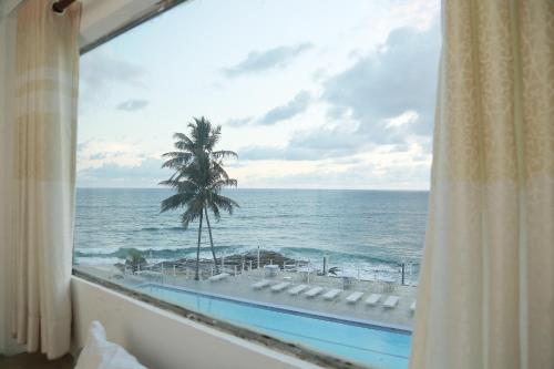 a view of the ocean from a hotel room window at New Ocean Hill Hotel in Hikkaduwa