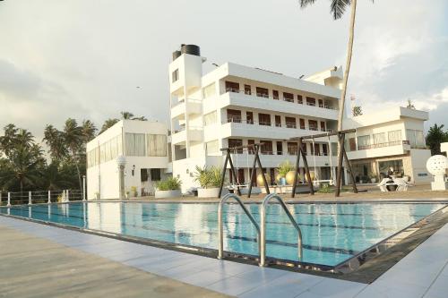 a swimming pool in front of a building at New Ocean Hill Hotel in Hikkaduwa