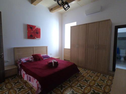 a bedroom with a large bed and a large cabinet at Charming Townhouse - Steps from Waterfront in Marsaxlokk