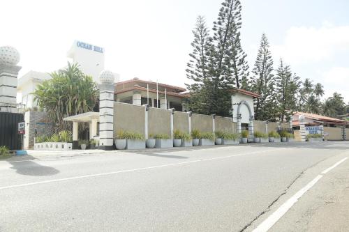 an empty street with a fence and a building at New Ocean Hill Hotel in Hikkaduwa