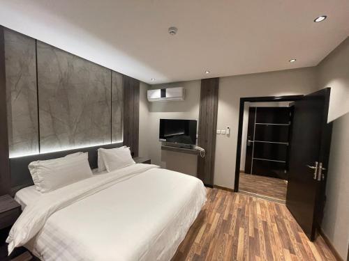 a bedroom with a large white bed and a television at شقق درر رامه للشقق المخدومة 2 in Riyadh