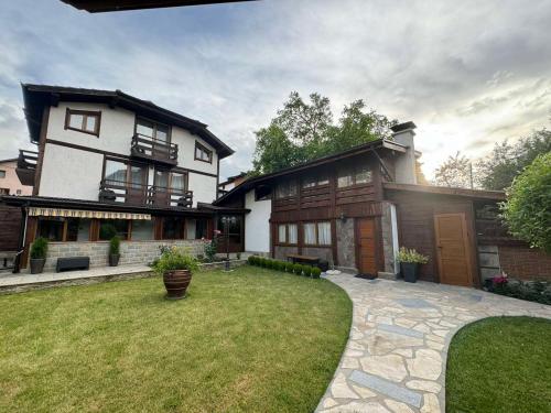 a large house with a lawn in front of it at Guest House Ivan in Bansko