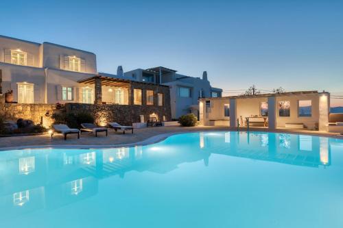 a swimming pool in front of a house at Villa Zanetti Mykonos in Agios Ioannis Mykonos