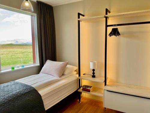 a small bedroom with a bed and a window at Hrossholt in Stykkishólmur
