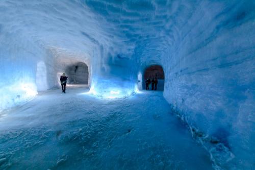 a person walking through an ice cave in an ice tunnel at Hrossholt in Stykkishólmur