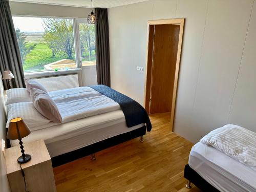 a bedroom with two beds and a window at Hrossholt in Stykkishólmur