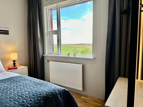 a bedroom with a bed and a window at Hrossholt in Stykkishólmur